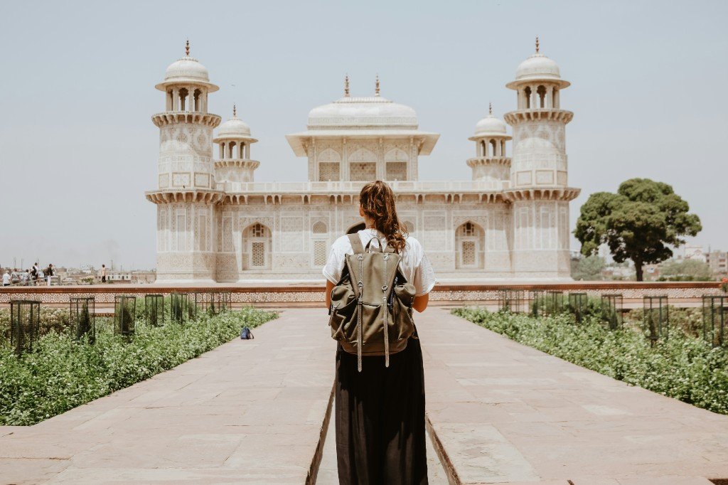 Viajera con mochila frente a un monumento histórico